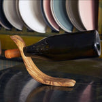 Tunisian olive wood wine bottle holder displayed on a flat surface